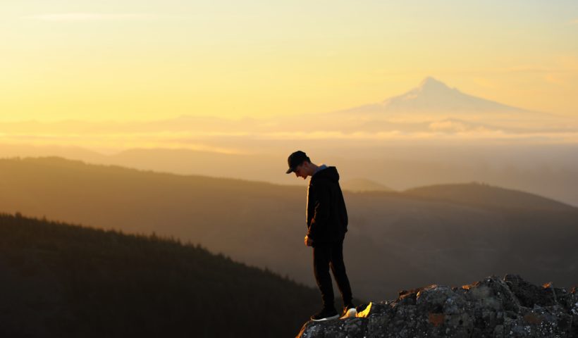 man looking down a mountain top