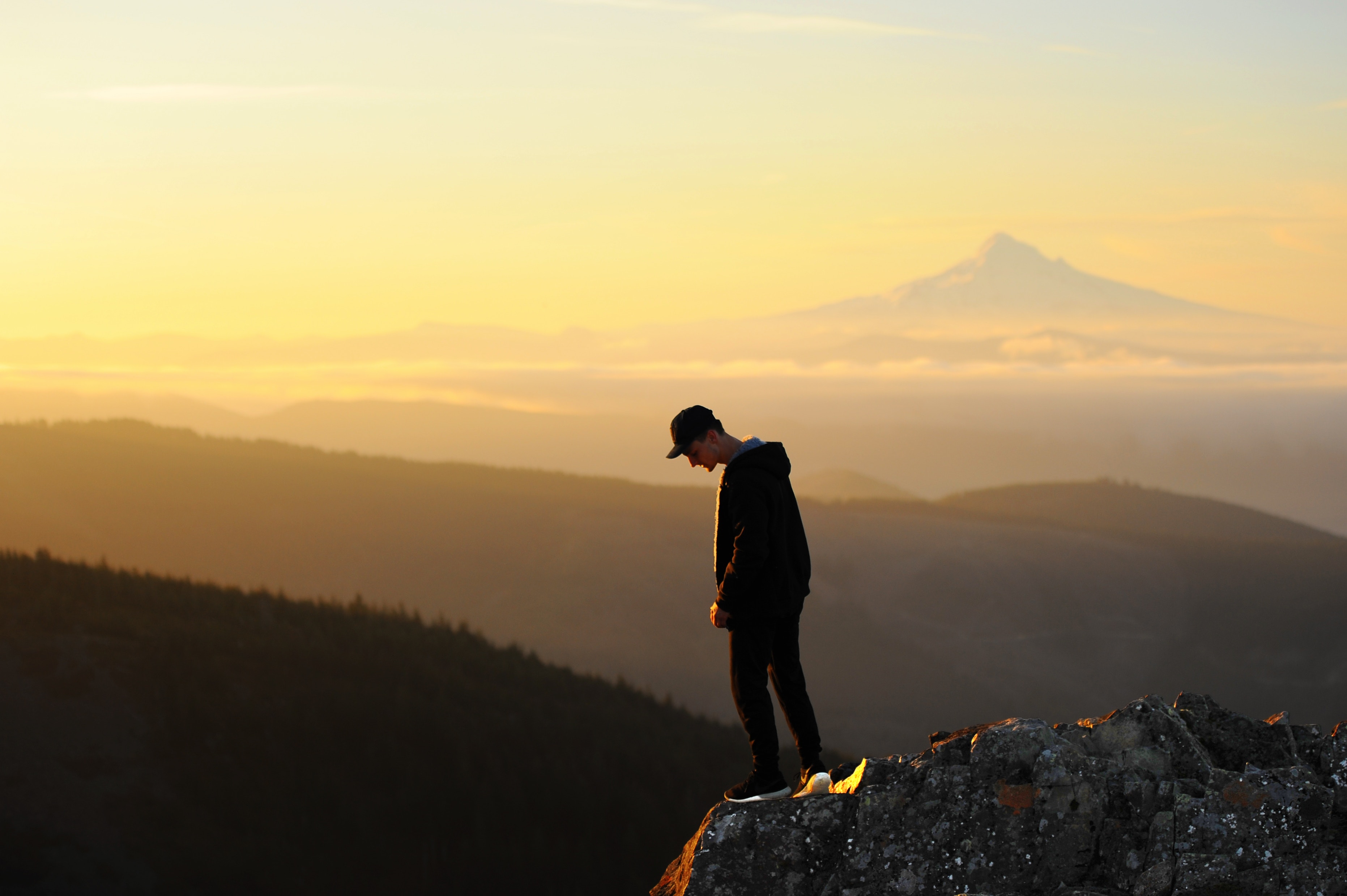 man looking down a mountain top